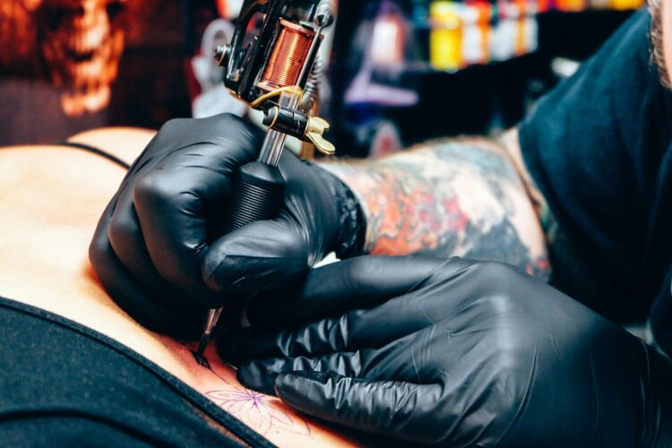 A man with a tattoo on his arm holding a gun