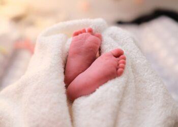baby covered with white blanket